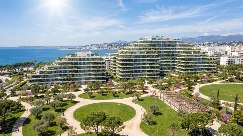 Terraced green apartment buildings around a park by the sea