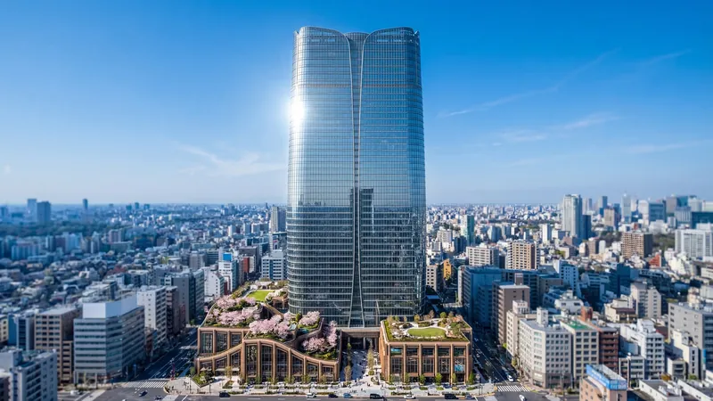Glass high-rise with green podium roofs above a dense city