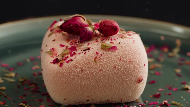 Pink dessert topped with rosebuds and petals