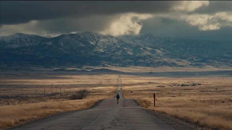 Lone figure on a road through the plains